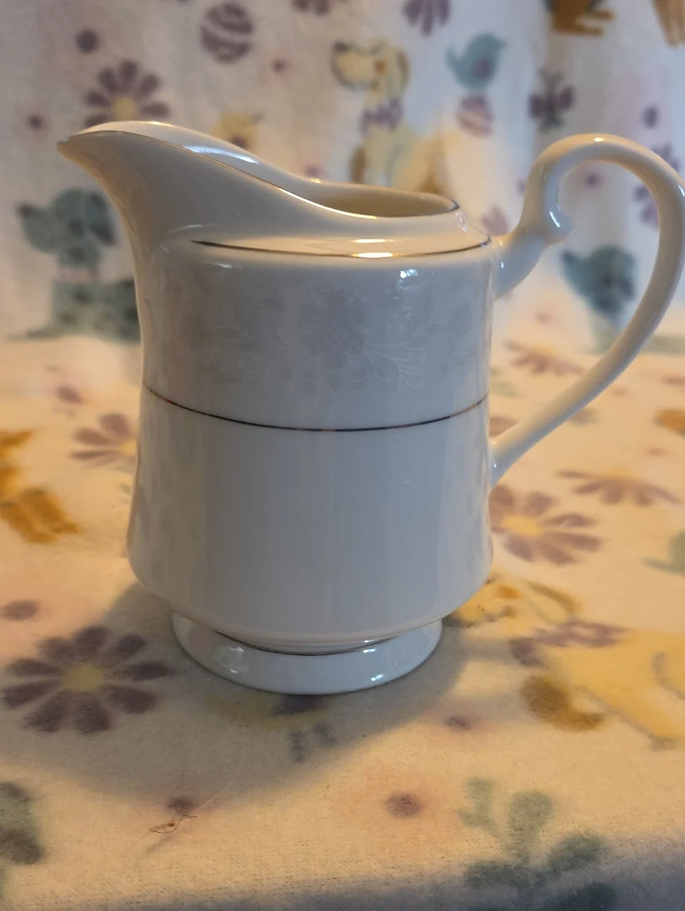 White Porcelain Creamer with Subtle Floral Relief and Silver Trim